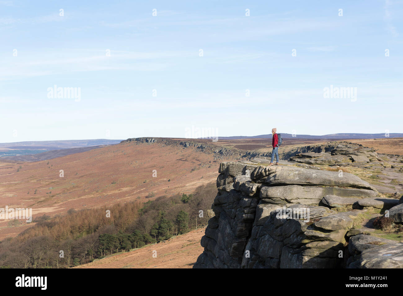 UK, Derbyshire, Peak District Nationa Park, a walker on the cliff edge of Stanage Edge. Stock Photo