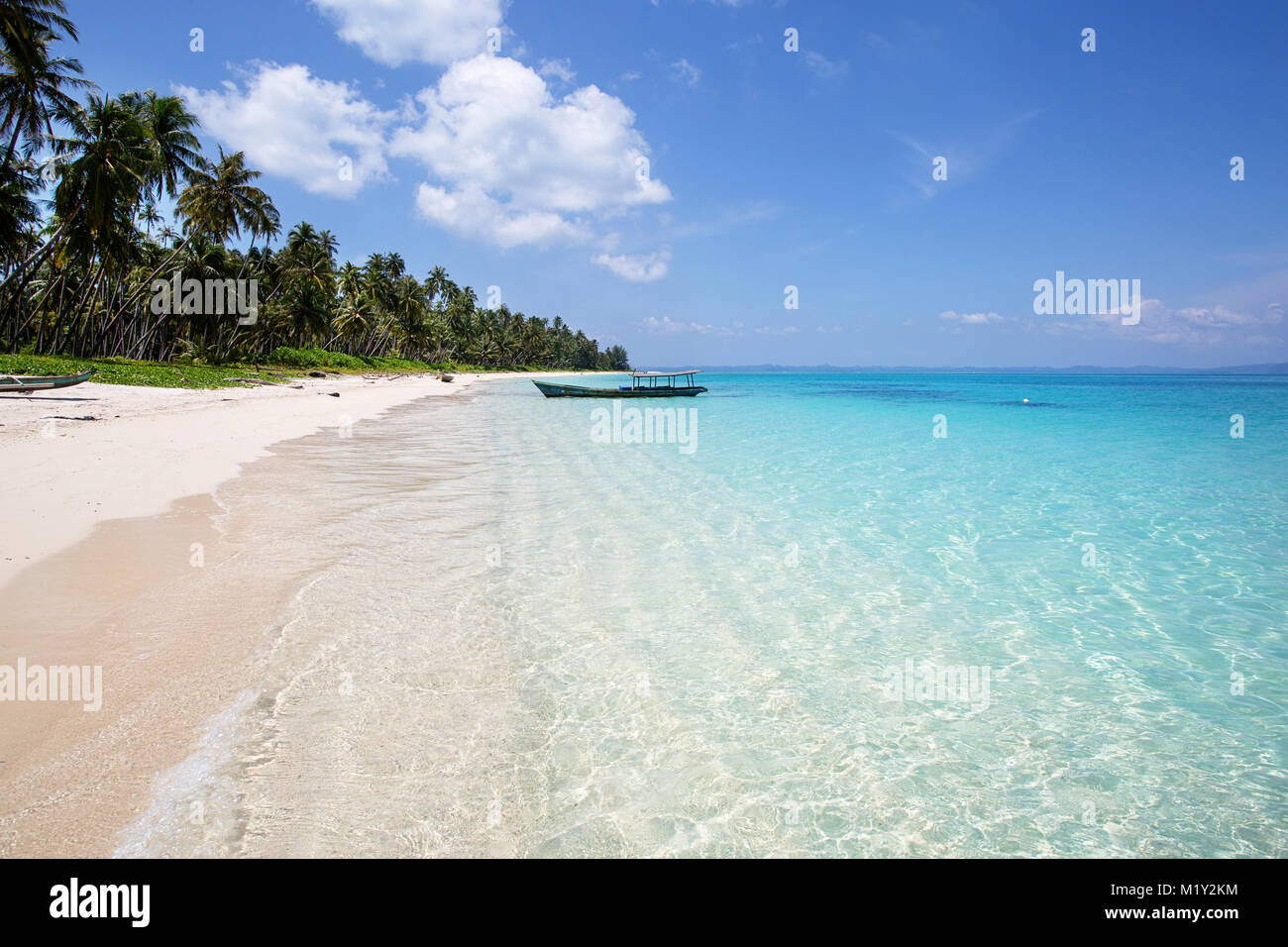 Beautiful tropical beach with crystal clear turquoise water and traditional boat Stock Photo