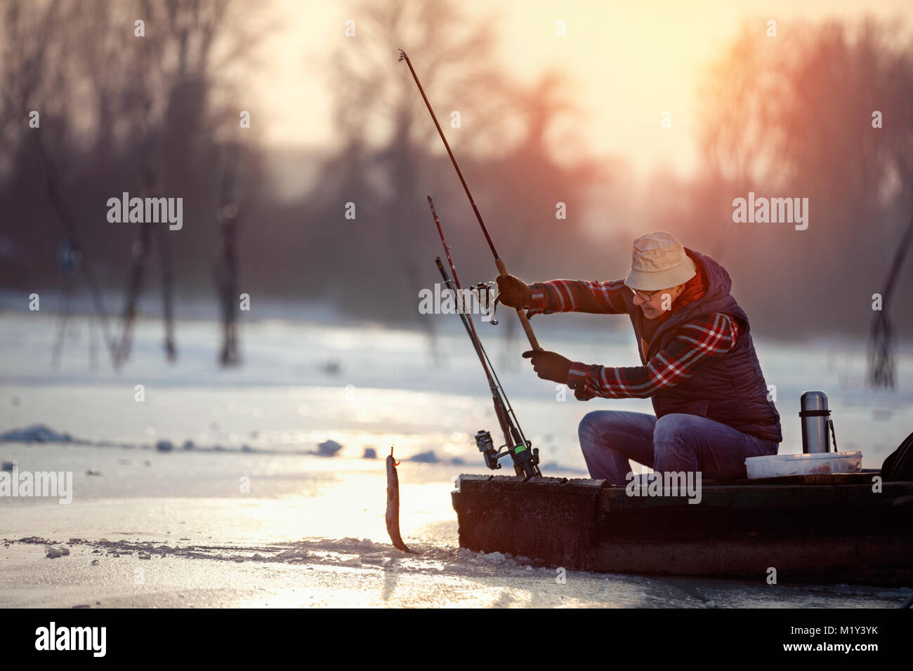 Ice fishing on frozen lake hi-res stock photography and images - Alamy