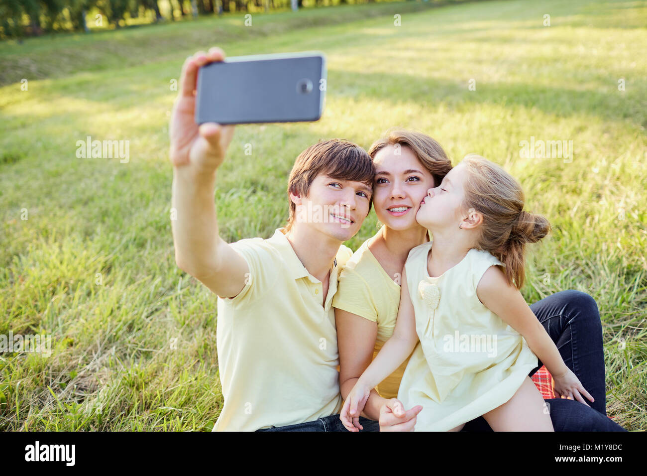 Happy smiling family being photographed in the park Stock Photo