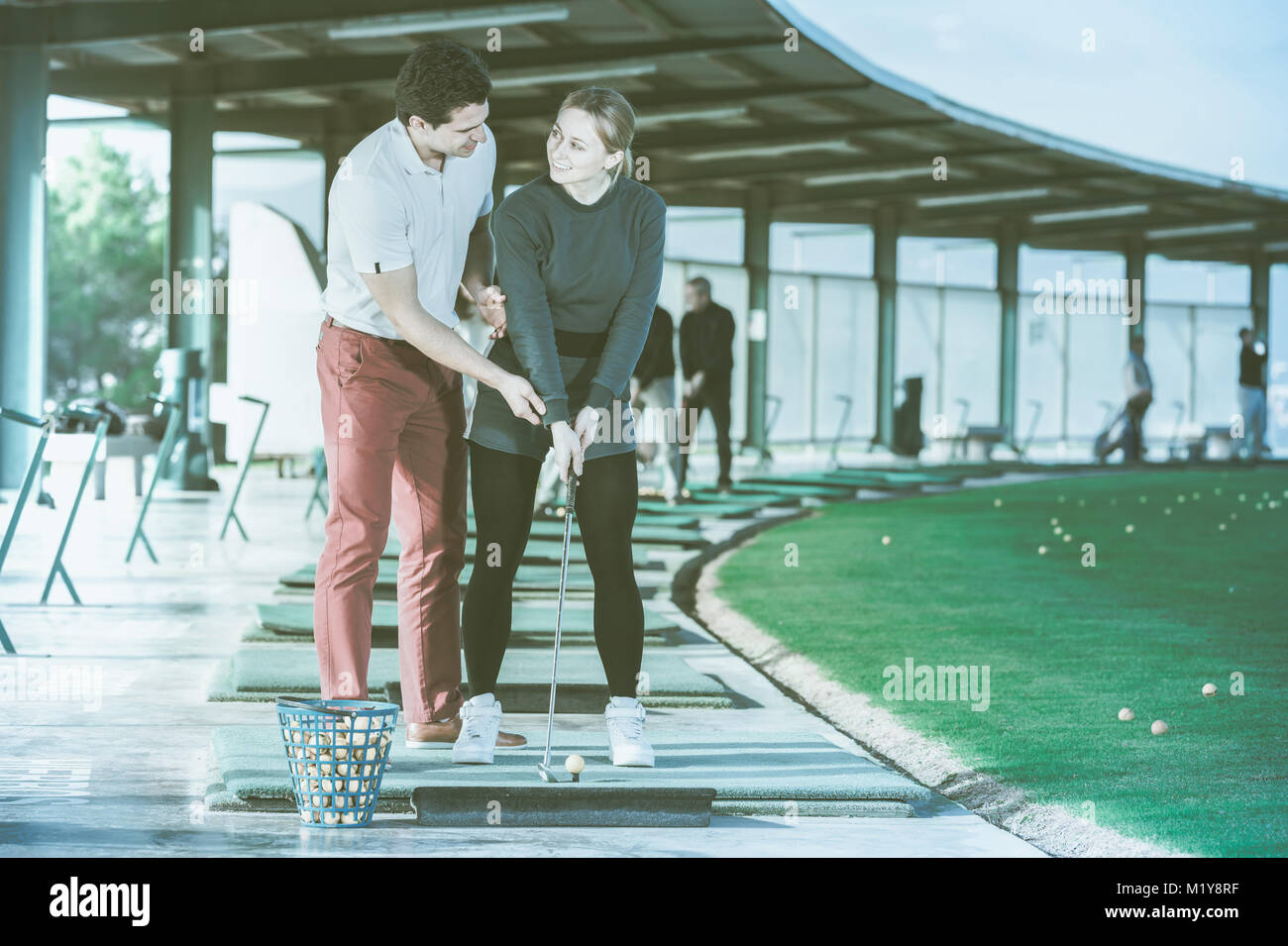 Coach golf shows a young girl right ways strikes a golf ball Stock