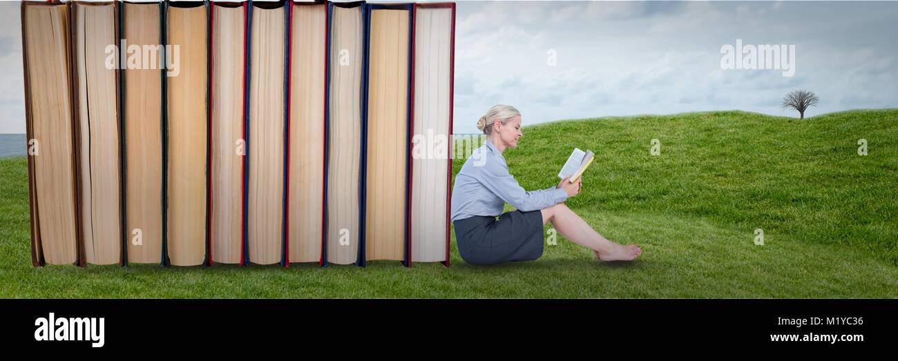 Business woman reading next to books outdoors Stock Photo