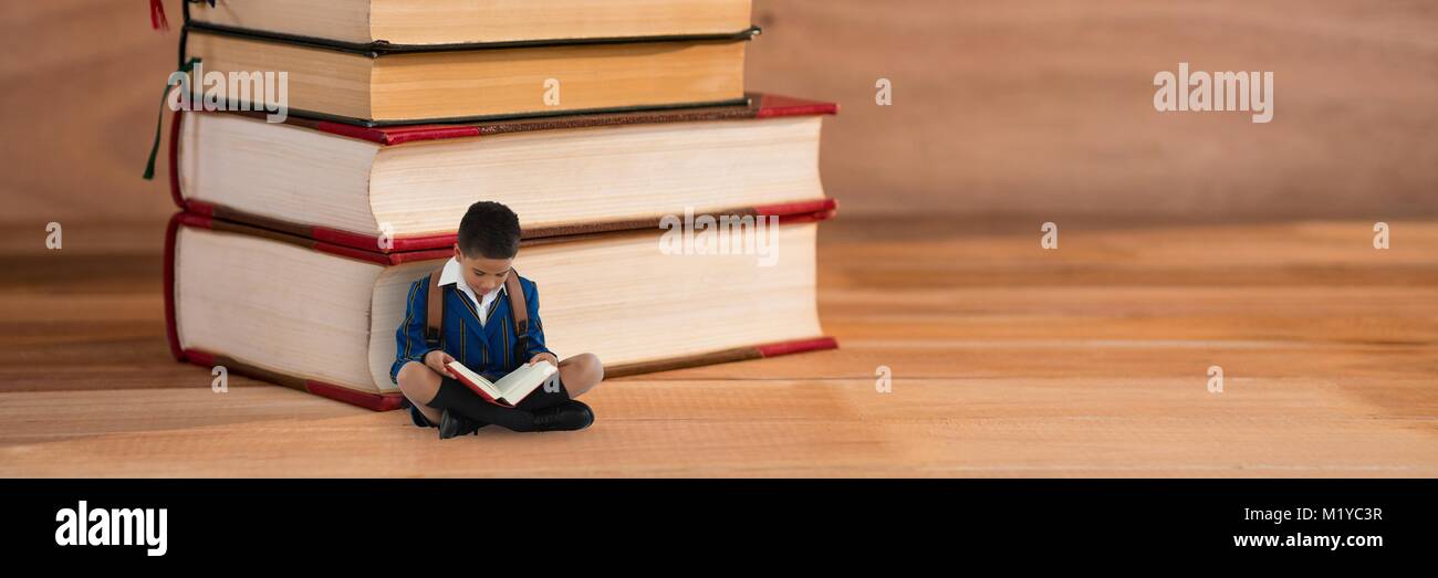 Boy reading on the floor next to a pile of books Stock Photo - Alamy