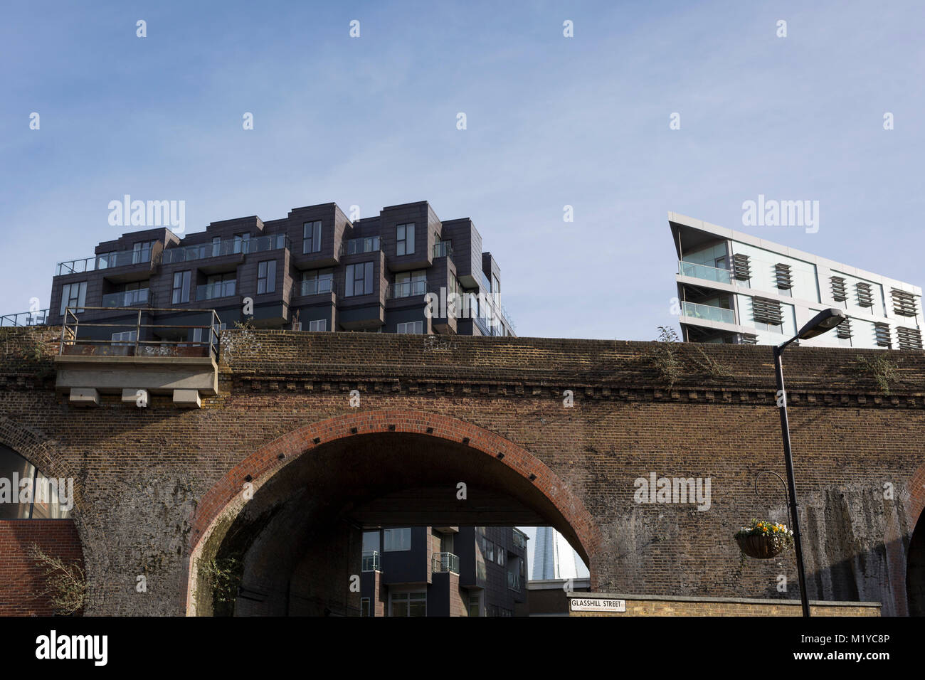 Old Victorian railway bridge and new housing in the borough of Southwark, on 30th January 2018, in London, England. Stock Photo