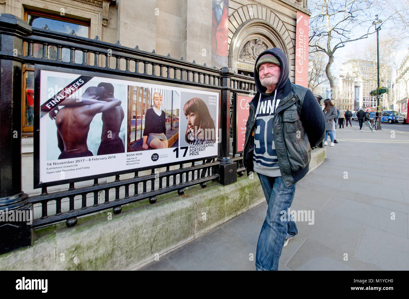 London, England, UK. Man walking past the National Portrait Gallery, St Martin's Place during a Photographic Portrait Prize exhibition Stock Photo