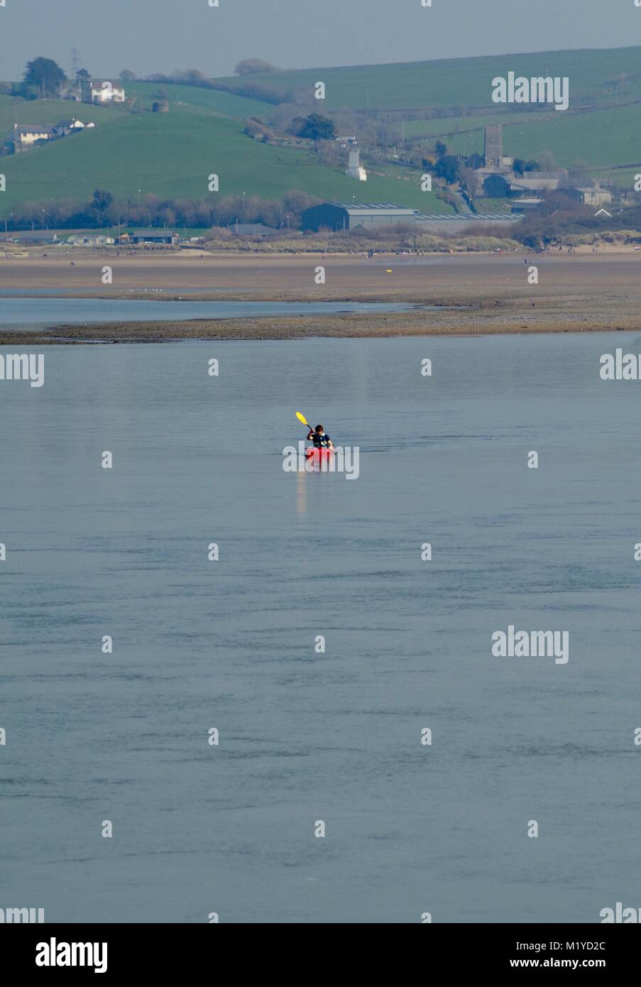 Lone Kayaker Paddling a Red Kayak Down the River Taw in a Landscape of