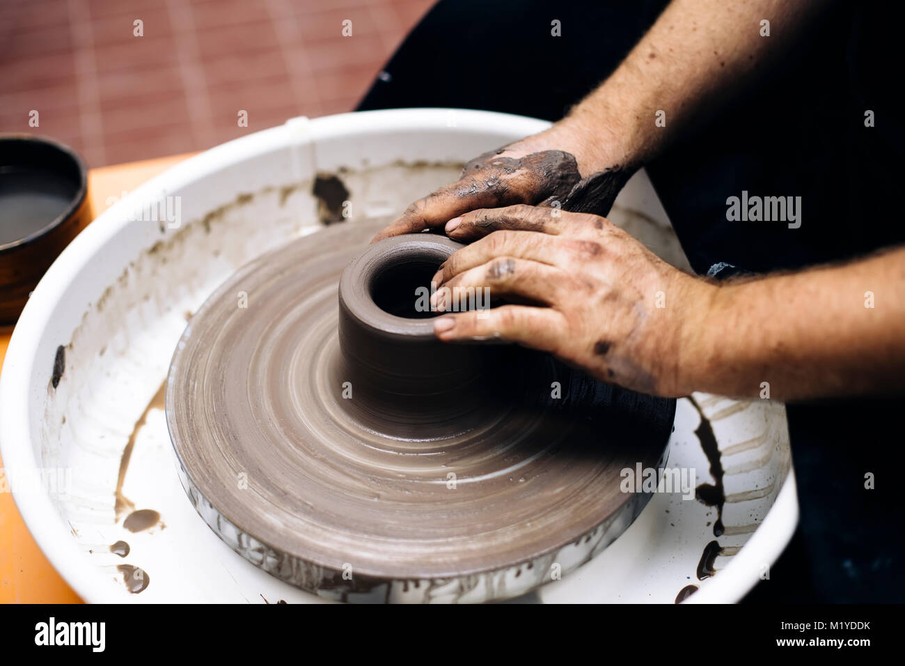 Close up detail view at an artist makes clay pottery on a spin wheel