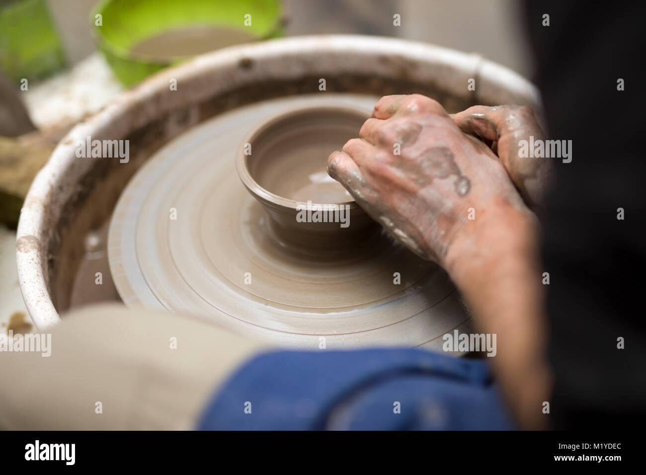 Close up detail view at an artist makes clay pottery on a spin wheel