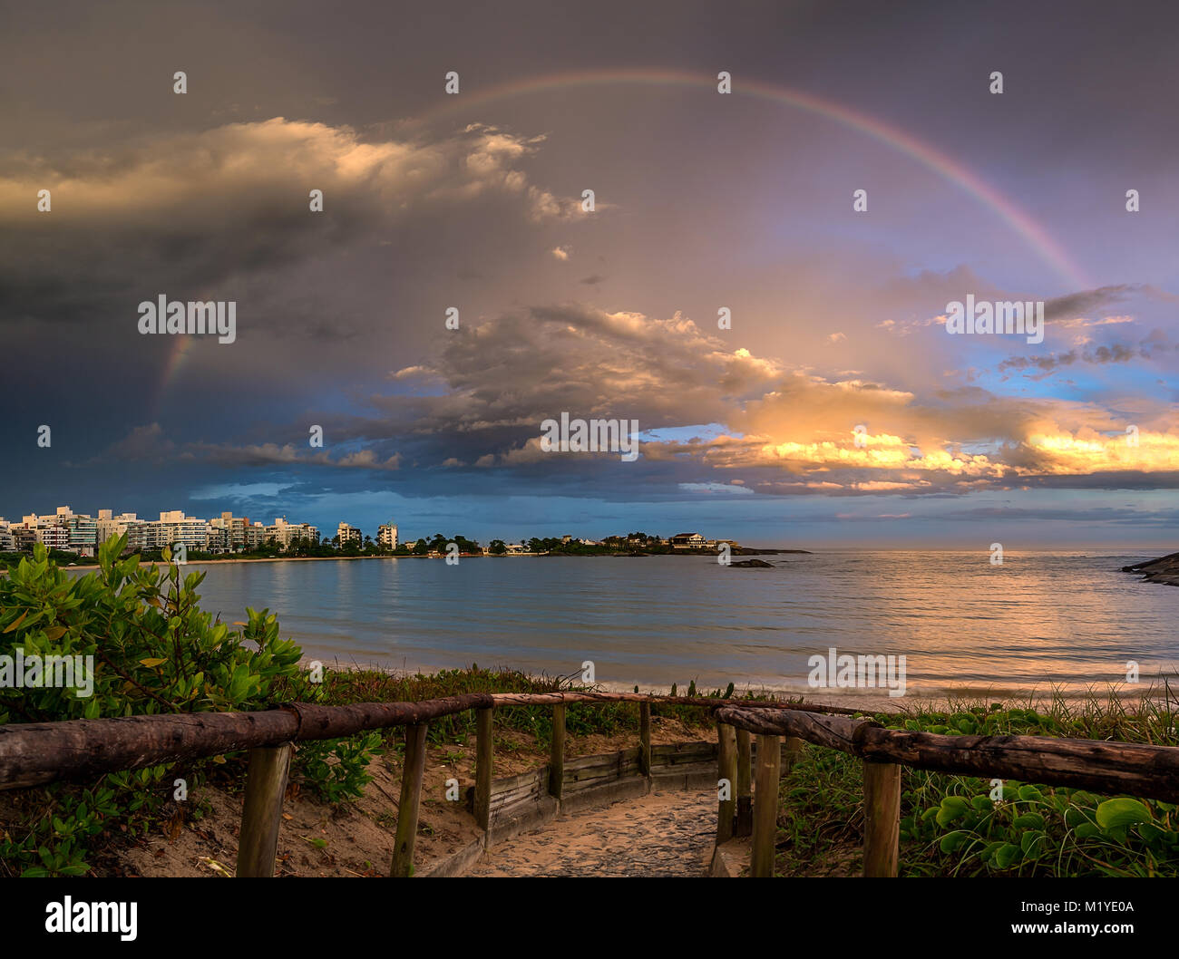 Rainbow over Peracanga Beach with a pathway to the sand. Guarapari, Espirito Santo State, Brazil. Stock Photo