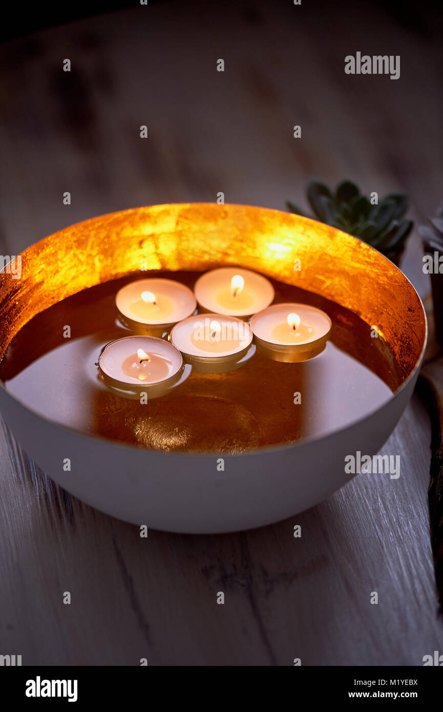 Floating candle and petals in brass bowl containing water Stock Photo -  Alamy