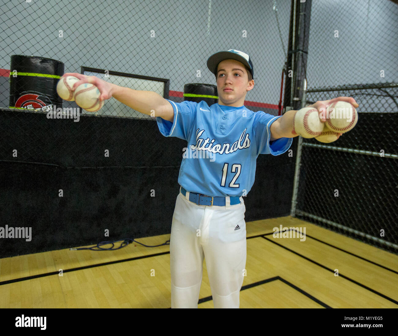 Baseball player doing arm and hand strengthening exercises at an indoor