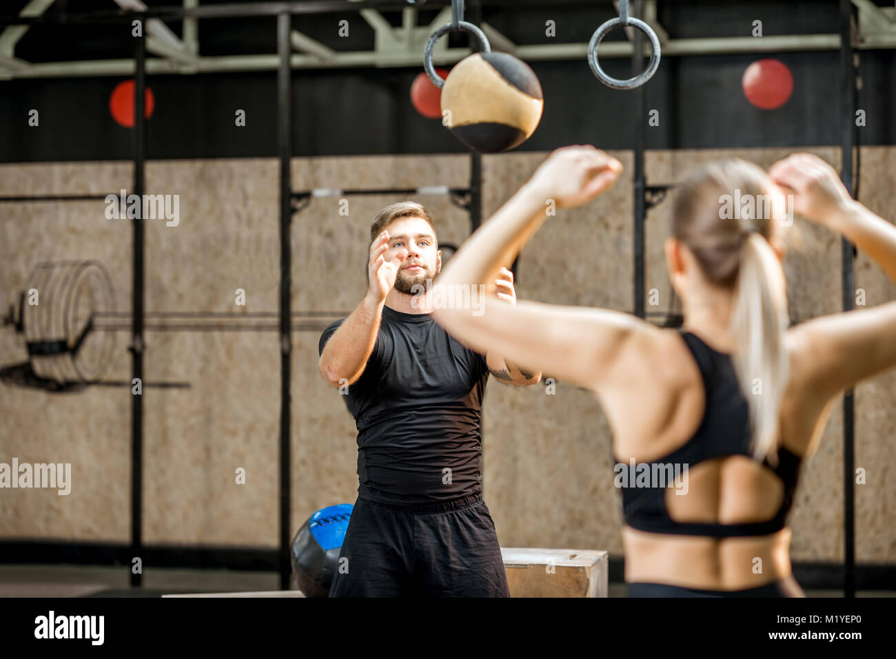 Young couple training with ball in the gym Stock Photo - Alamy