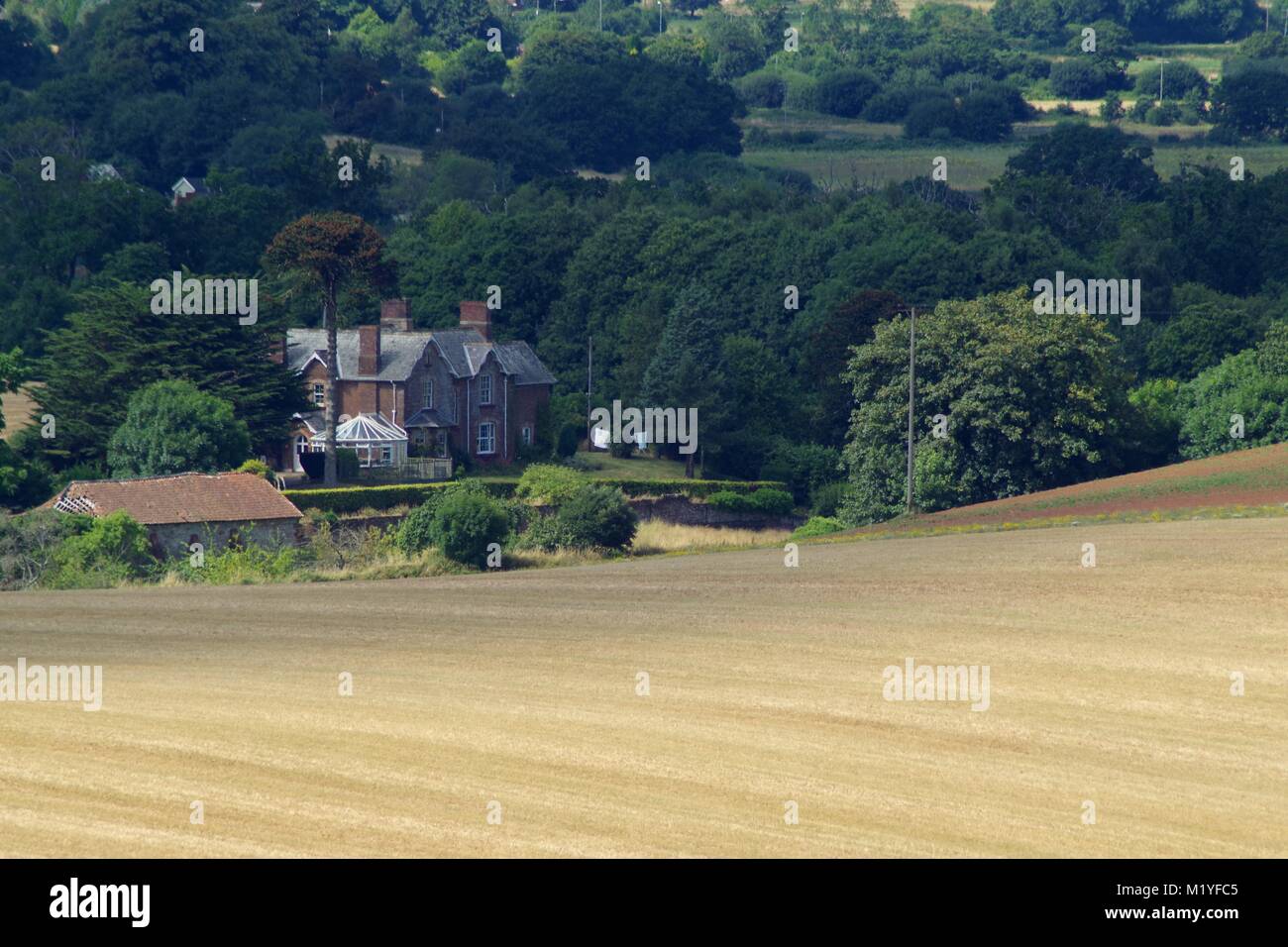 Old Country House on the Edge of Woodland with Late Summer Straw Field