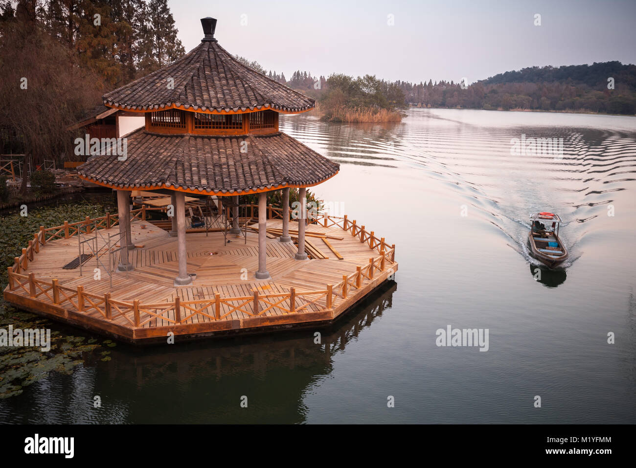 Chinese landscape with traditional wooden gazebo on coast of West Lake, popular public park of Hangzhou city, China Stock Photo