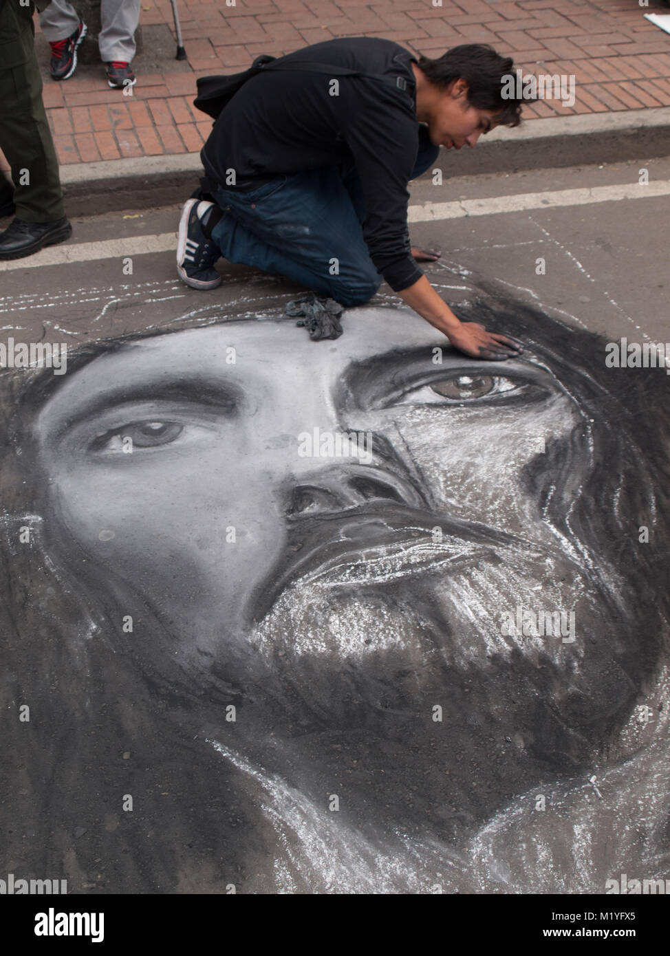 Painting Christ face with chalk  in the pavement in a Bogota street Stock Photo