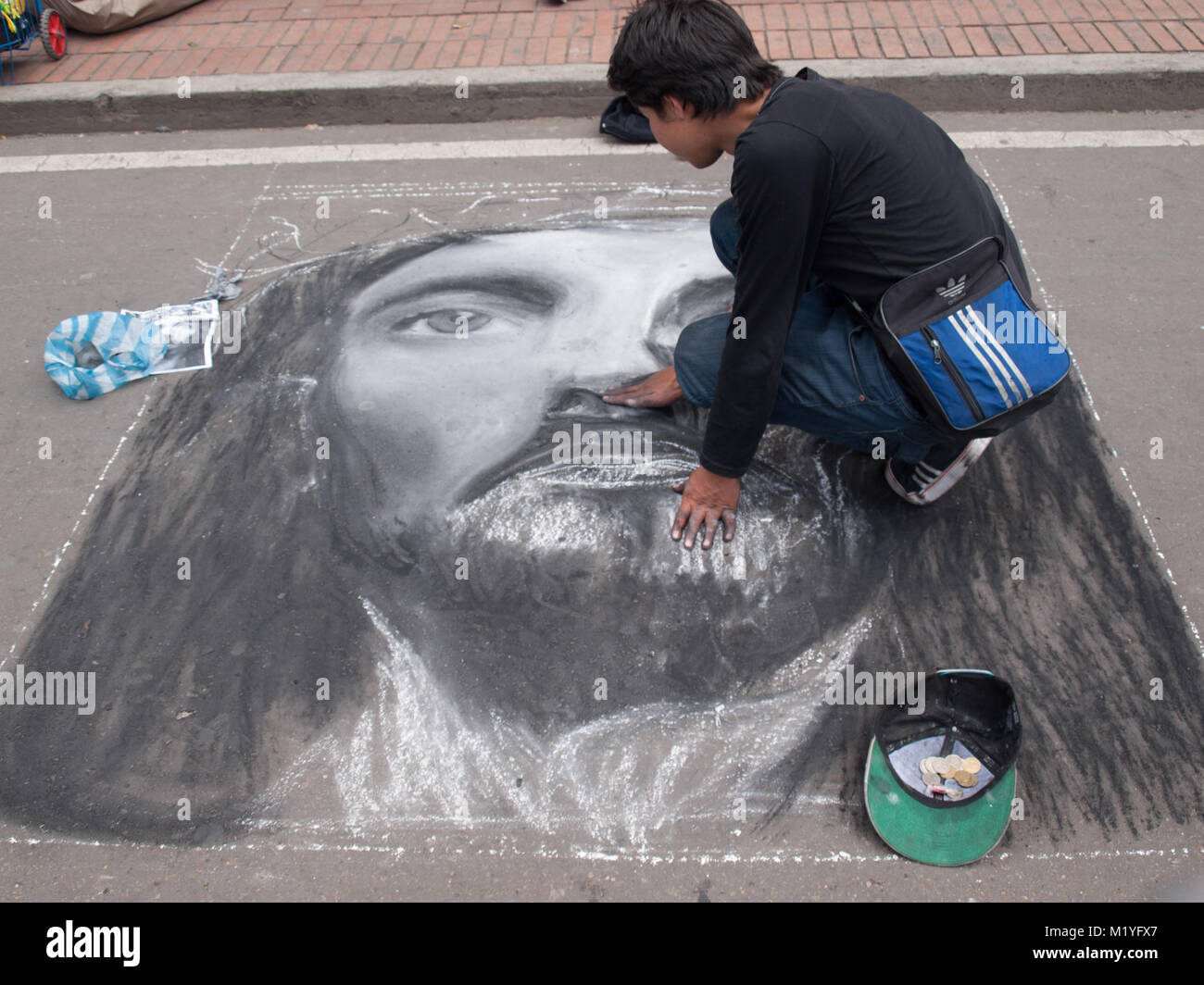 Painting Christ face with chalk  in the pavement in a Bogota street Stock Photo