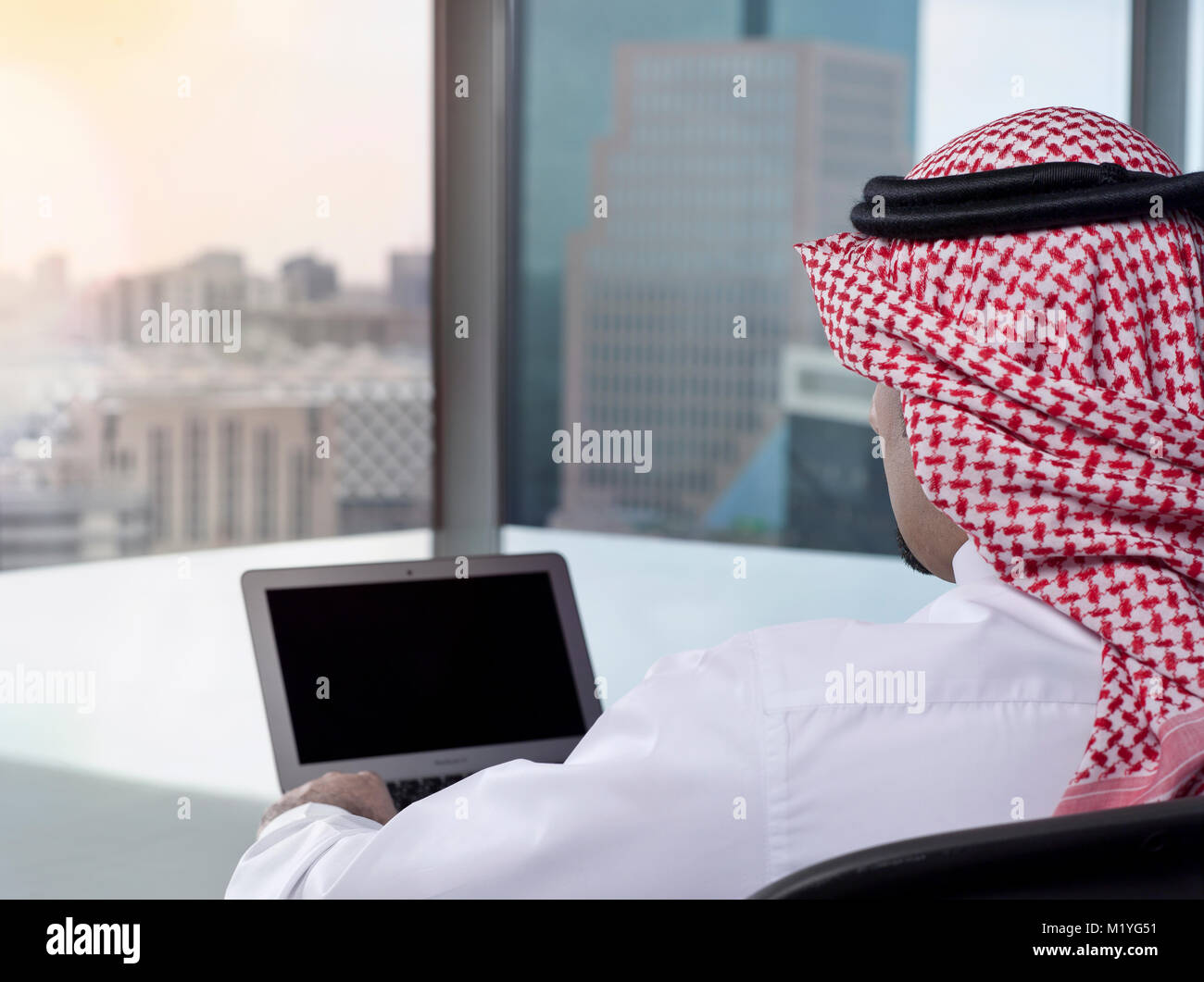 Saudi Arab Man Watching Laptop at Work and Contemplating Stock Photo