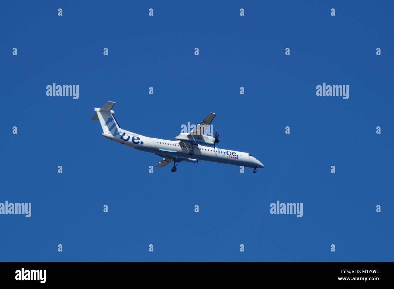 Flybe Propeller Aeroplane Coming Into Land at Exeter Airport, Flying against a Blue Sky. Exeter, dEvon, UK. Stock Photo
