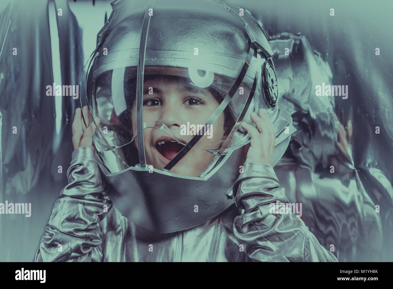 Future, Boy playing to be an astronaut with space helmet and metal suit ...