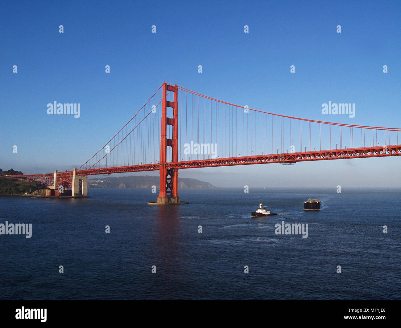 tugboat pulling tanker under Golden Gate Bridge in San Francisco California Stock Photo