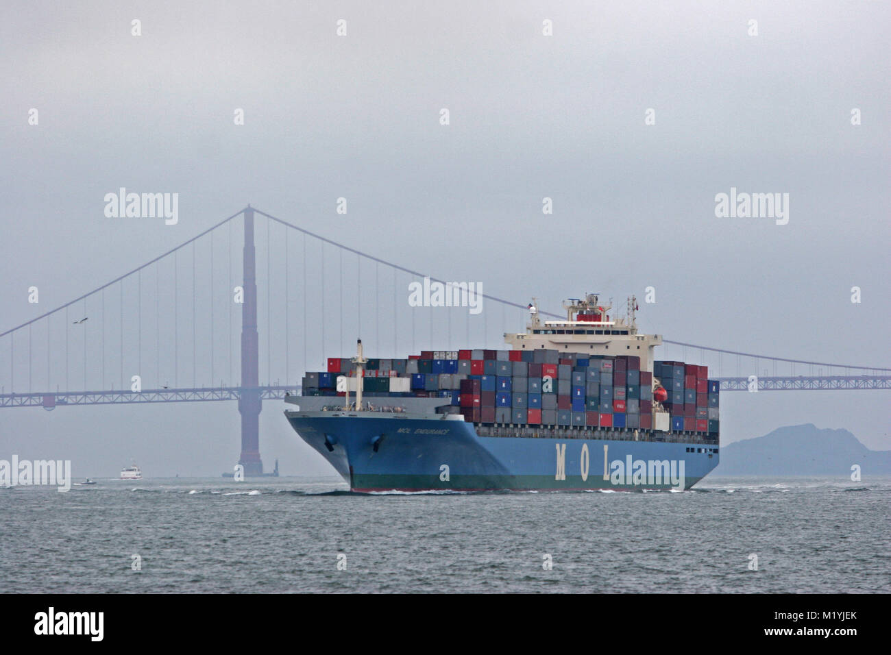 Ship loaded with containers enters bay under Golden Gate Bridge in San Francisco California Stock Photo