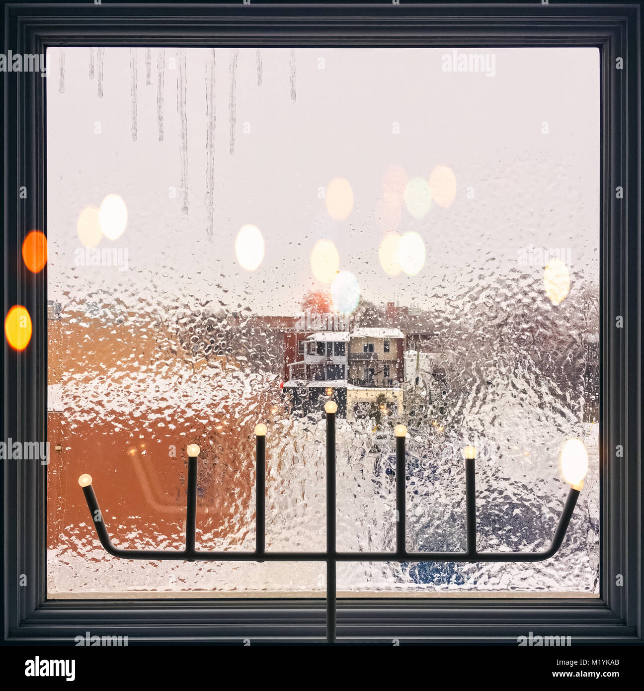 Icicles on a frosted window decorated with lights. Christmas mood Stock