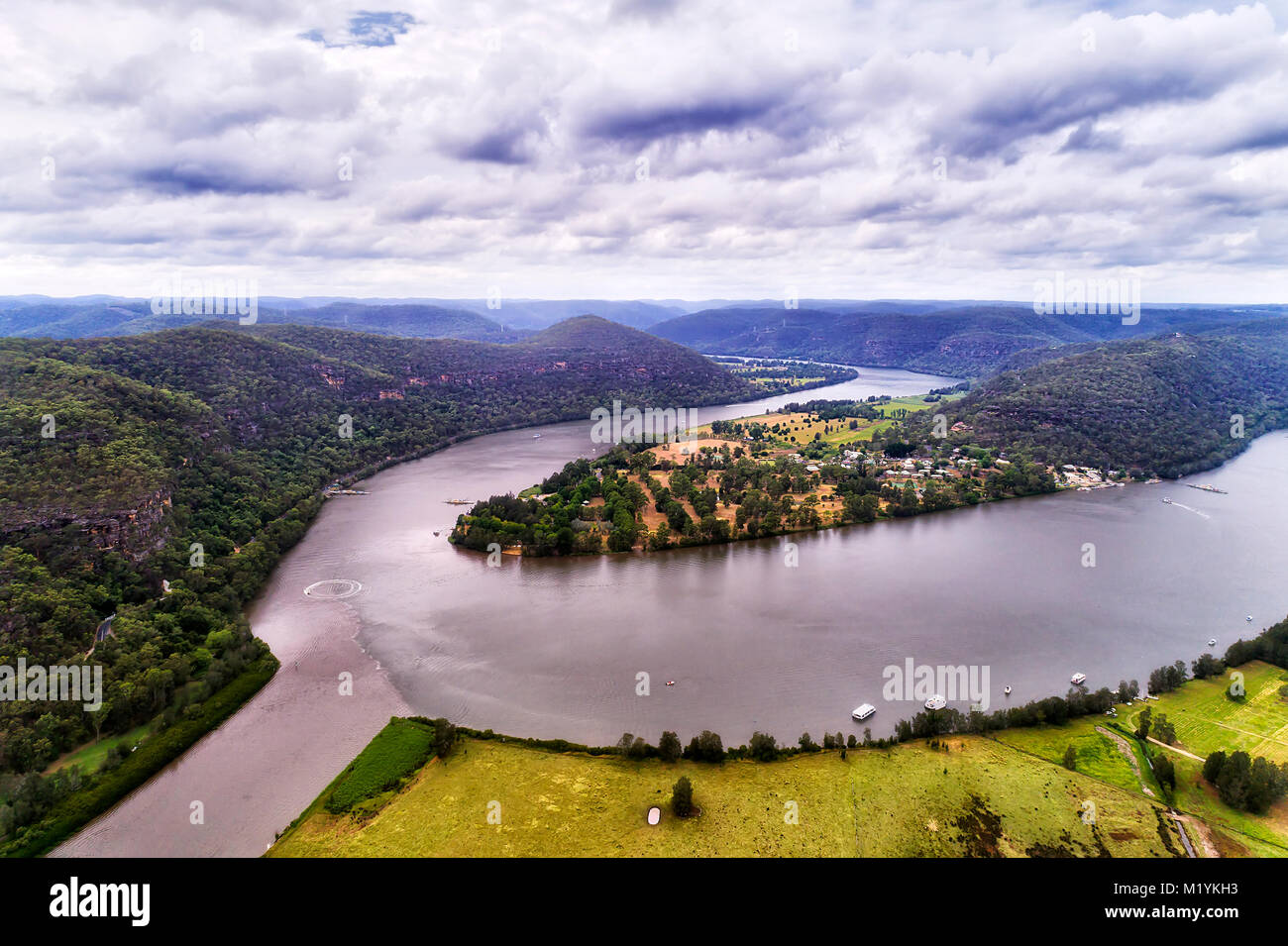 Macdonalds river merges into Hawkesbury river near Wisemans ferry regional town in Blue Mountains national park of australia - elevated aerial view wi Stock Photo