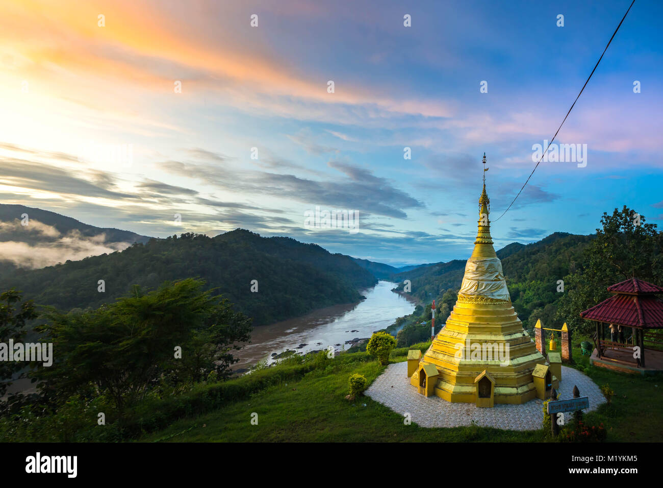Gold pagoda over Salween river on Mae Hong Son province between Thailand and Myanmar border in twilight. Stock Photo