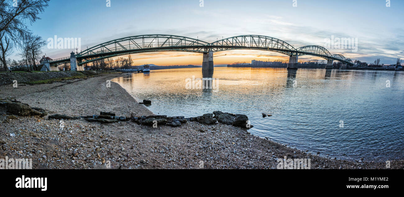 Maria Valeria bridge joins Esztergom in Hungary and Sturovo in Slovak republic across the Danube river. Transportation theme. Sunset scene. Stock Photo