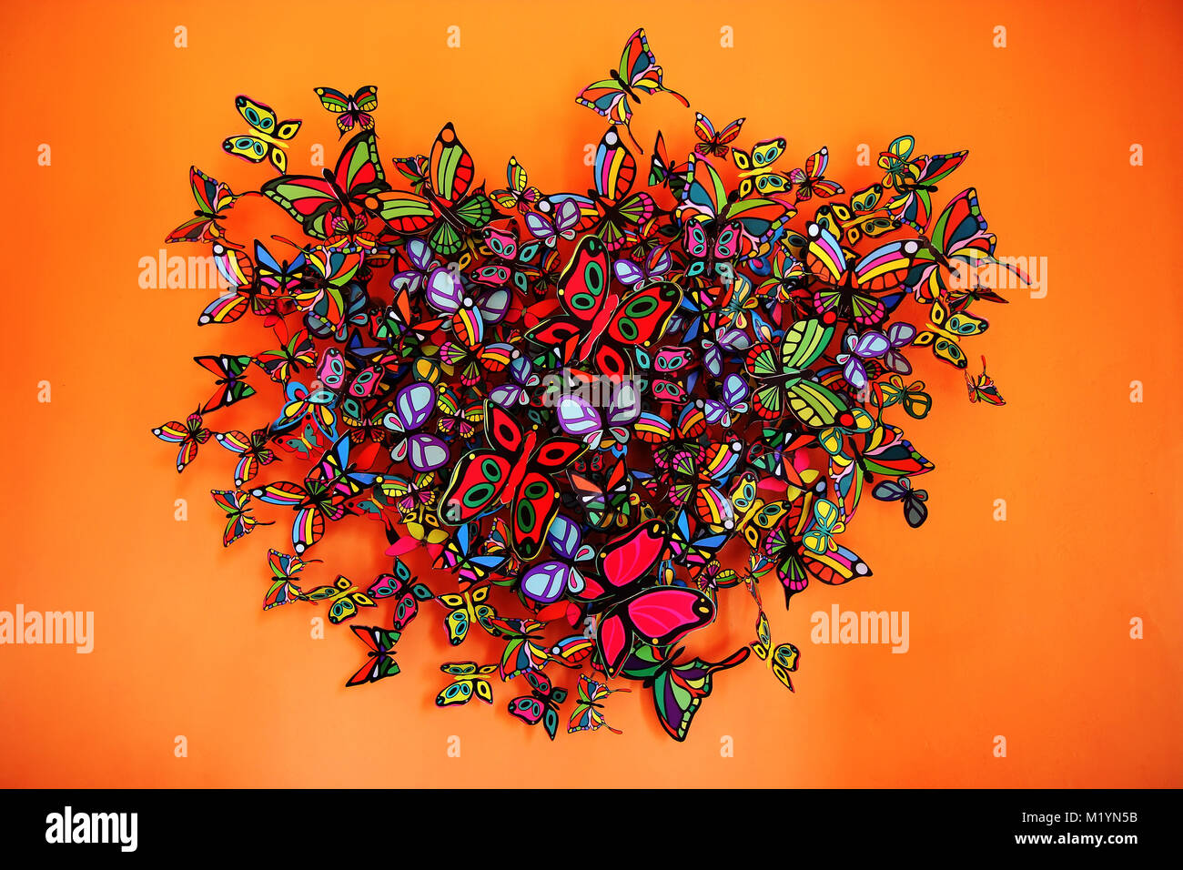 Butterflies heart shape grouping on orange background Stock Photo Alamy