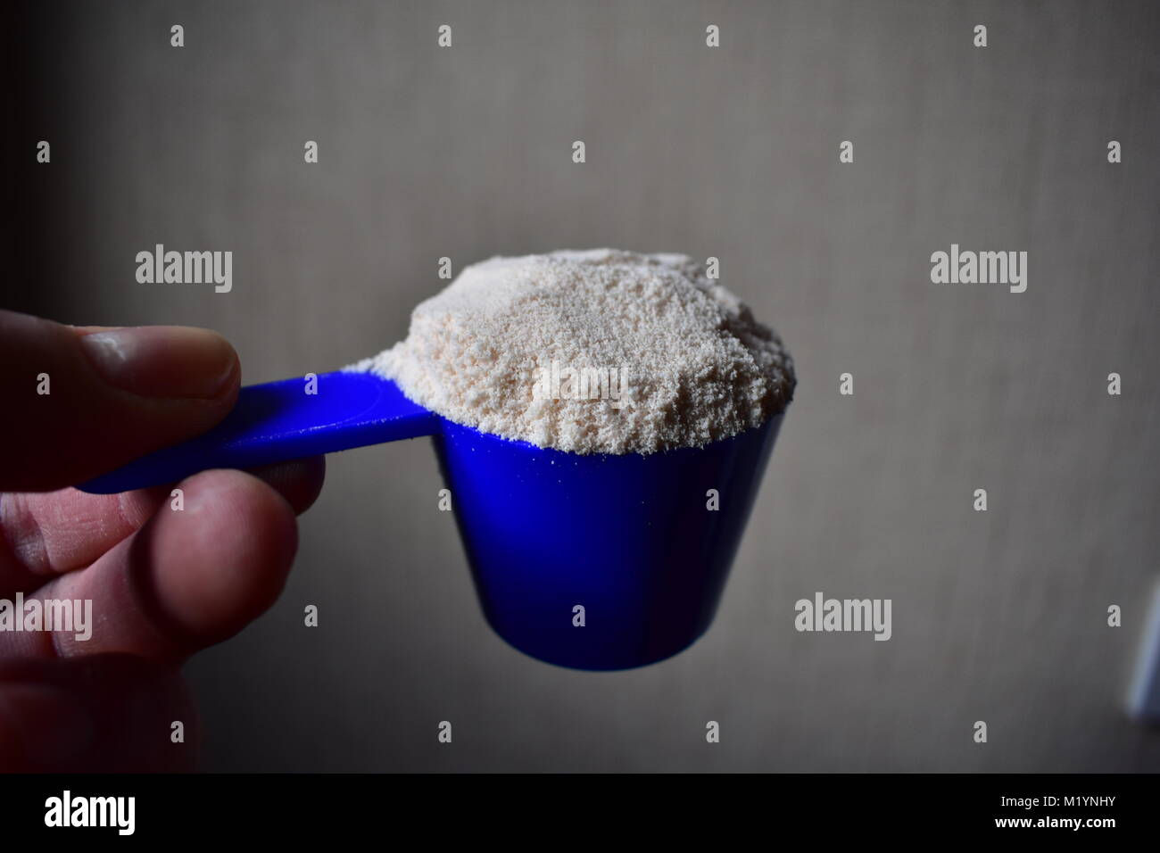 man holding scoop of protein powder Stock Photo