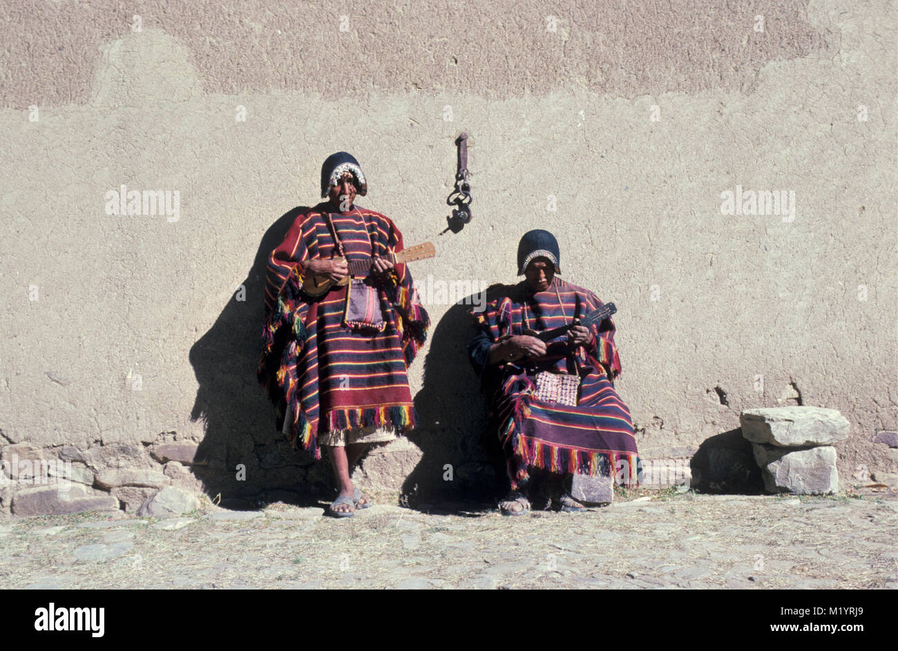 Bolivia. Tarabuco. Indian men in traditional clothing (Mock Conquistador Helmet) playing little gitar called: chirango. Stock Photo