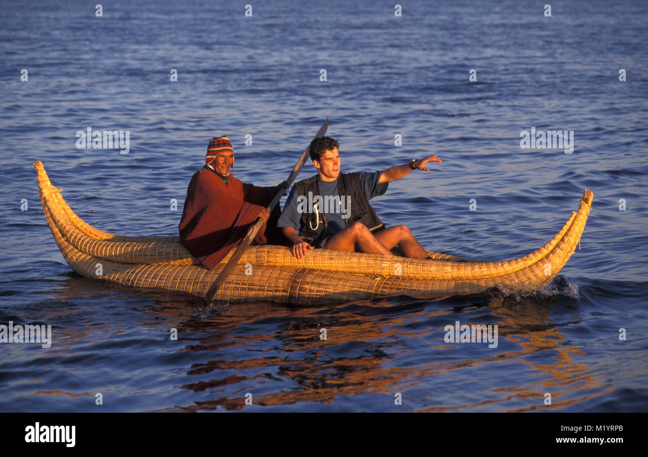 Bolivia. Copacabana. Titicaca lake. Andes mountains. Aymara indian fisherman in reed boat and tourist, man. Stock Photo