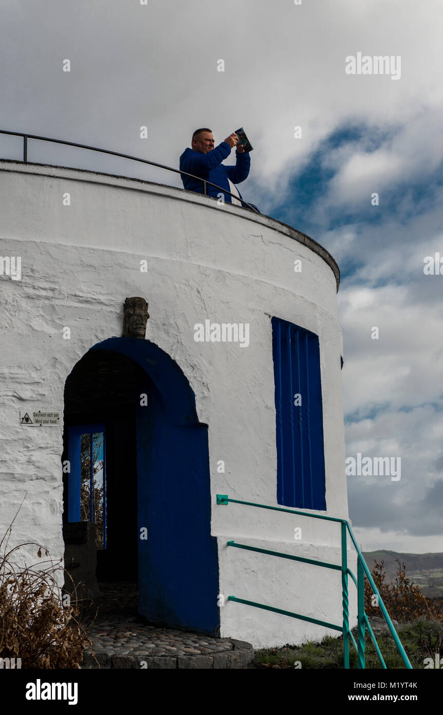 Man taking photograph from white viewpoint with blue door Stock Photo