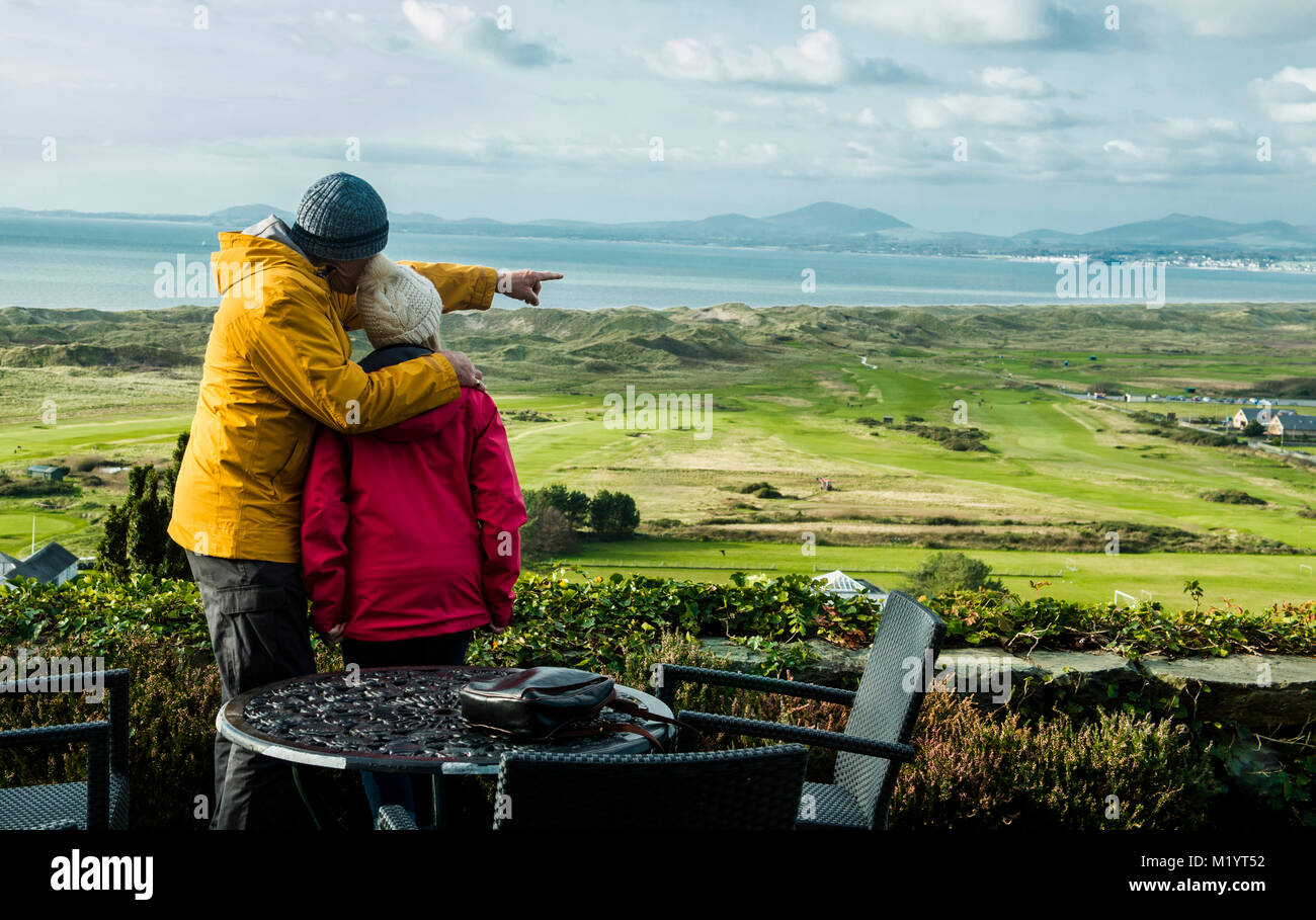 Couple looking at landscape, man pointing towards distance Stock Photo
