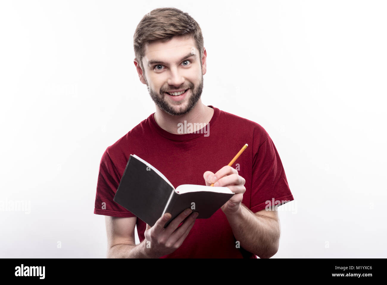 Excited young man making notes in his planner Stock Photo - Alamy