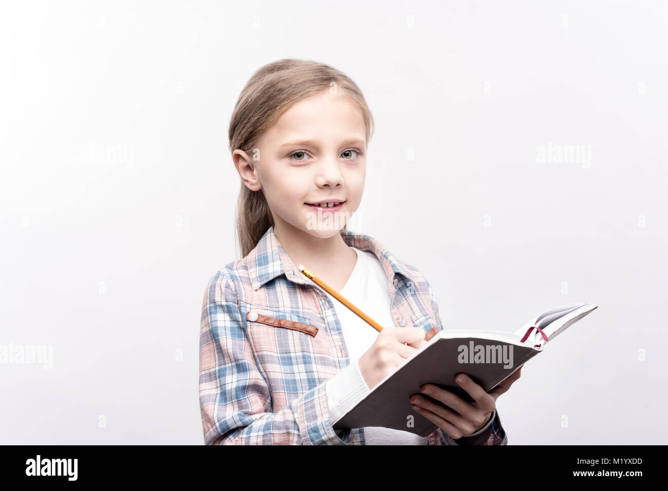 Charming little girl writing in a notebook Stock Photo Alamy