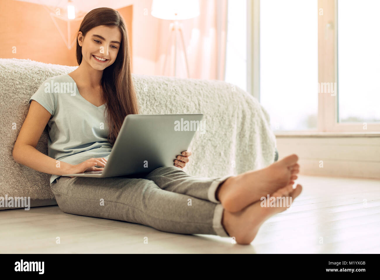 Beautiful teenage girl using her laptop while working on project Stock