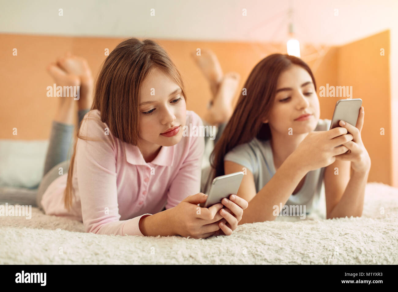 Pretty teenage girls being glued to their phones Stock Photo