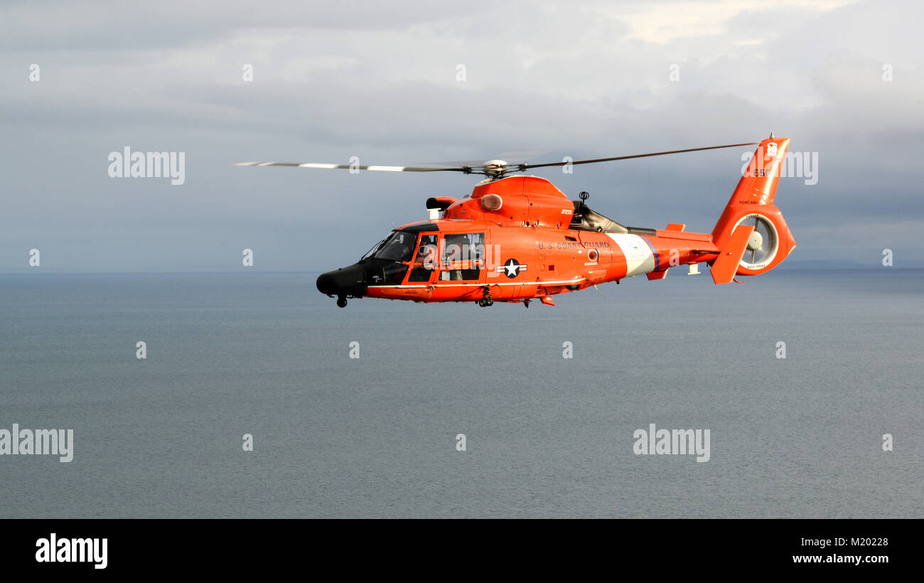A Coast Guard MH-65 Dolphin helicopter crew from Air Station Port Angeles flies of the Strait of Juan de Fuca, off the coast of Washington, Jan. 26, 2018.    Air Station has three Dolphin helicopters and is responsible for search and rescue response across the northern Washington coast.    U.S. Coast Guard photo by Chief Petty Officer David Mosley Stock Photo