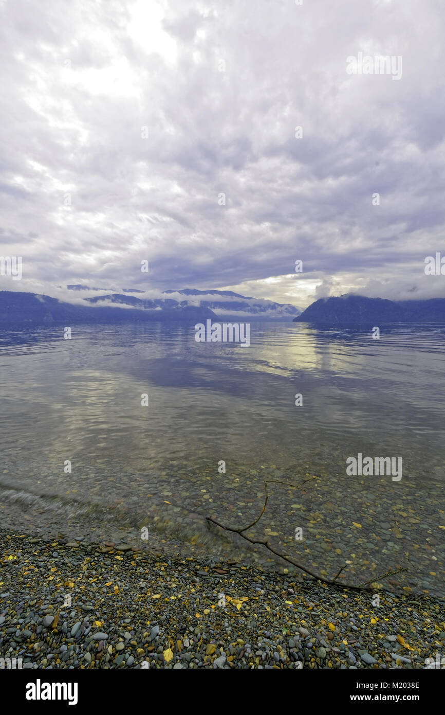 Clean clear water of lake Teletskoye. The wave incident on the beach Stock Photo