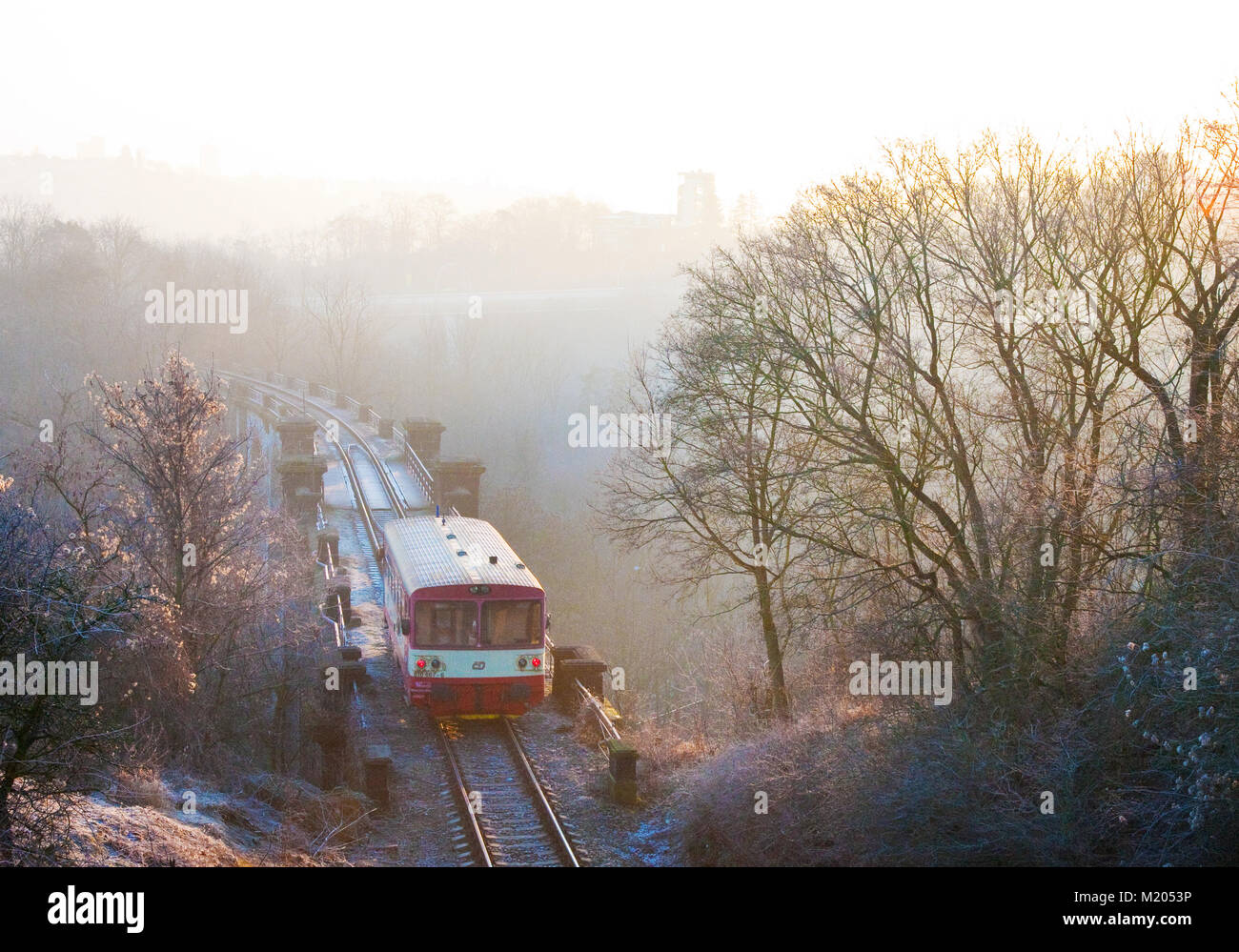personal train on bridge in Hlubocepy valley, Prague, Czech republic in a misty morning sunrise with snow covered landscape Stock Photo