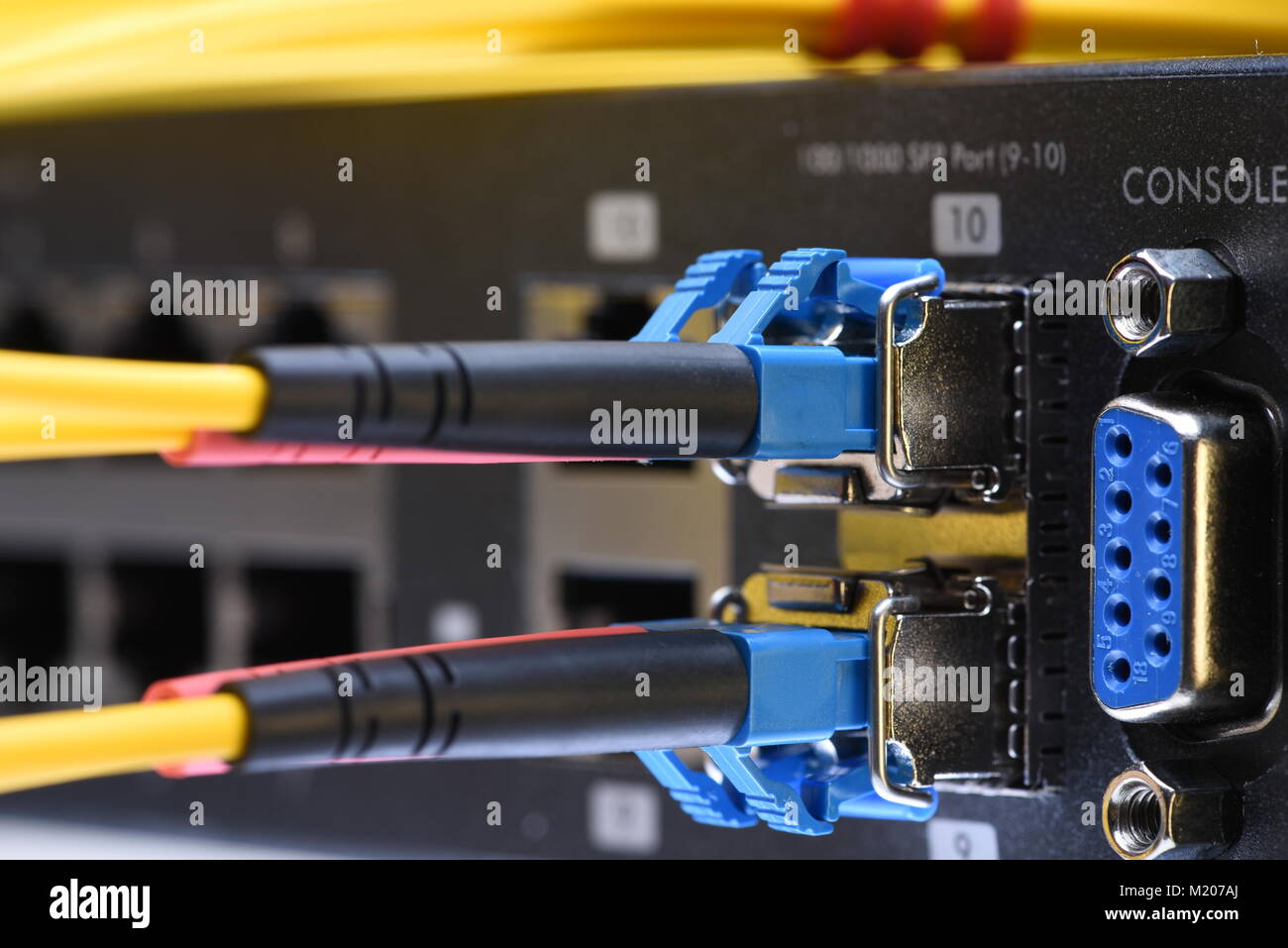Network optic fiber cables and switch in data center close-up Stock Photo