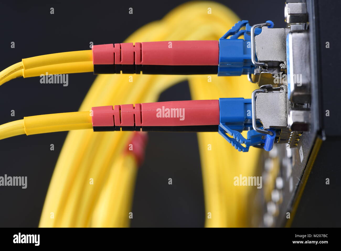 Internet network technology, fiber optic cable connected to switch in data center, close-up Stock Photo