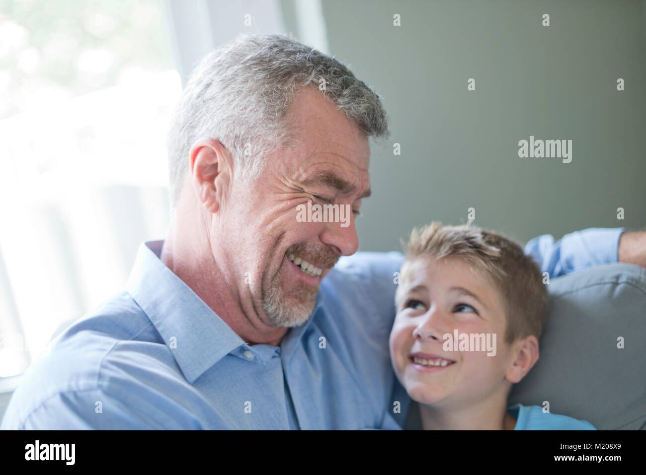 Portrait of grandfather and grandson smiling, face to face. Stock Photo