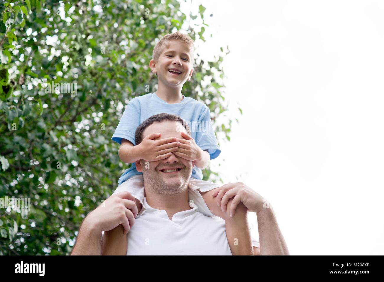 Father carrying son on his shoulders. Stock Photo