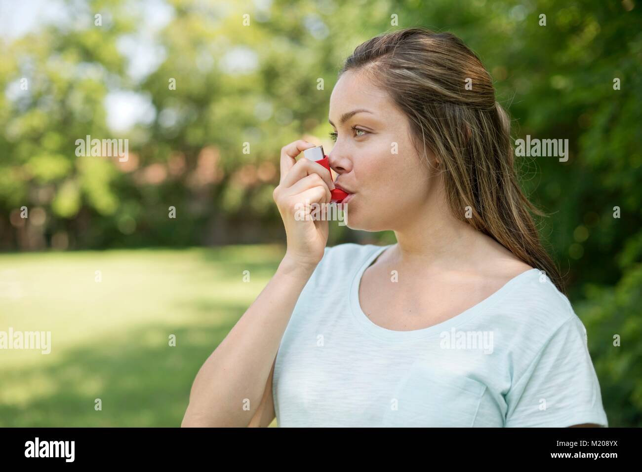 Young woman using an inhaler. Stock Photo