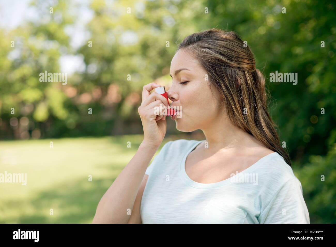 Young woman using an inhaler. Stock Photo
