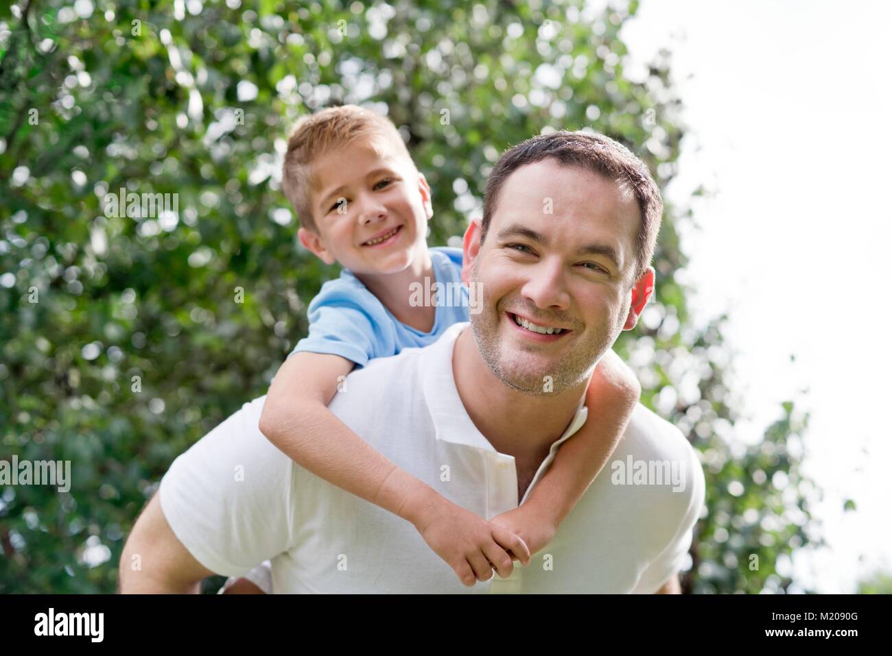 Father giving son piggy back. Stock Photo