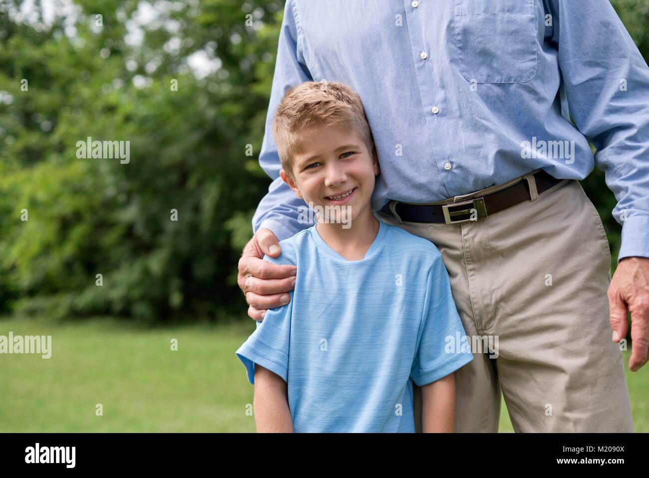 Man with arm around young boy, smiling. Stock Photo
